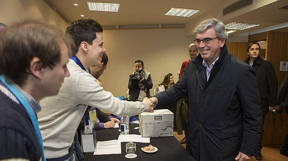 Mariano Marín, candidato a presidir el PP gijonés, saluda a los miembros de la mesa