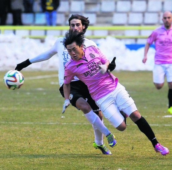 Kiu intenta irse de un jugador del Burgos en el partido de El Plantío.