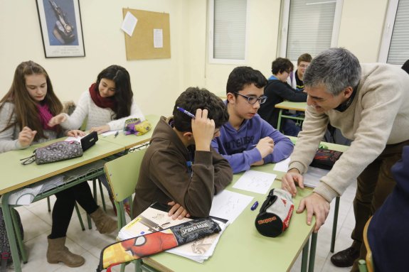 Un profesor ayuda a los alumnos en clase, en el instituto Emilio Alarcos, en Gijón. 