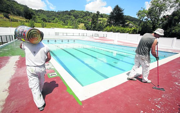 Tareas de limpieza de las piscinas del Riaño en julio del año pasado. 