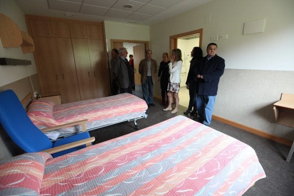 La consejera y la alcaldesa, entre otros invitados, visitan una de las 63 habitaciones del centro. 