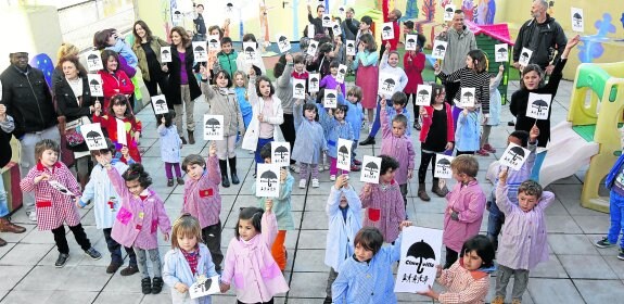 Los niños del colegio Honesto Batalón reivindican una cubierta para la pista del cerro con los simbólicos paraguas negros.