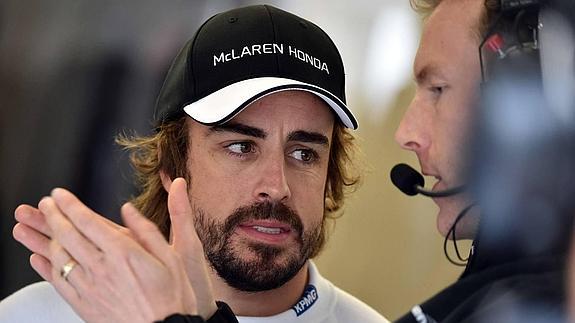 Fernando Alonso conversa con un miembro del equipo. 