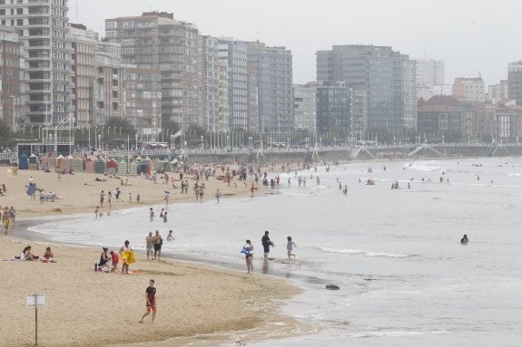 Bañistas en la playa de San Lorenzo, en Gijón, pese a que el día no acompañaba . 