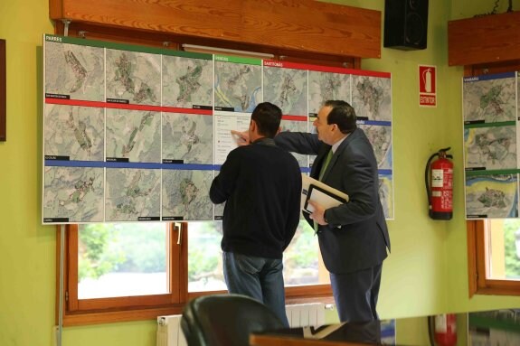 Dos personas consultan los planos del Plan General de Parres. 