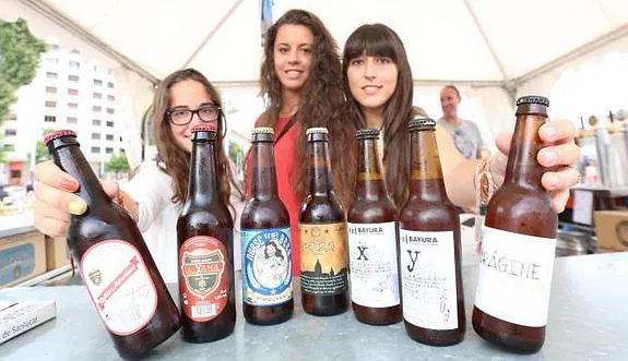 Las chicas del estand de la A.D. La Curtidora con las cervezas asturianas que ofertan.