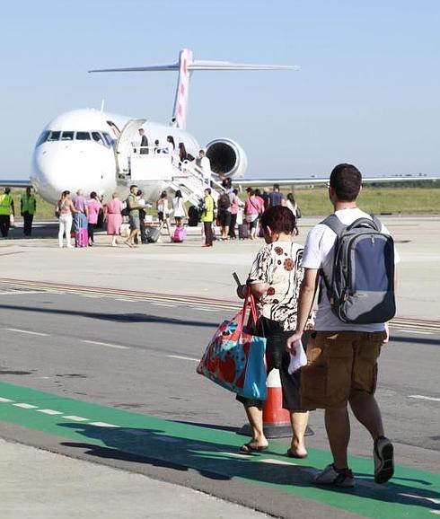 Viajeros se disponen a coger un avión de Volotea en el Aeropuerto de Asturias.