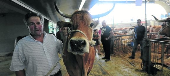 Un ganadero muestra con orgullo uno de los ejemplares con los que acude al certamen.
