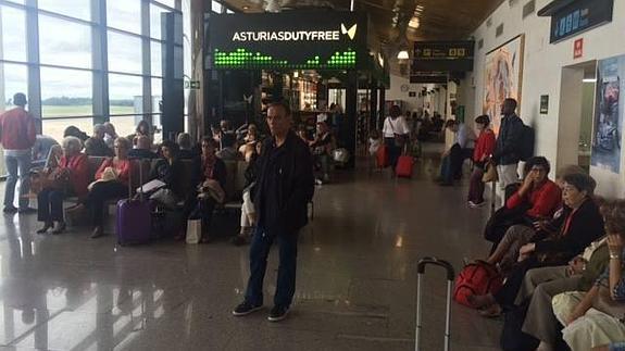 Viajeros del vuelo a París, esperando en la terminal.