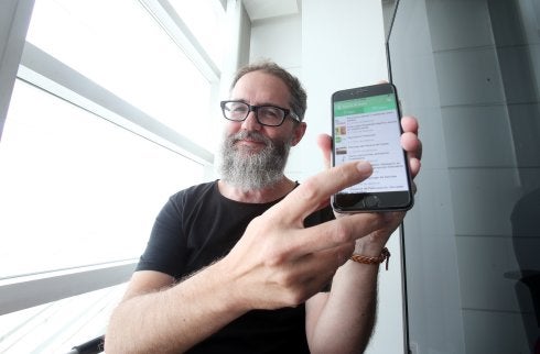 Rafael Cofiño muestra en su teléfono móvil la nueva app elaborada entre la Consejería de Sanidad y la Federación Asturiana de Concejos sobre actividades sanas y saludables. 