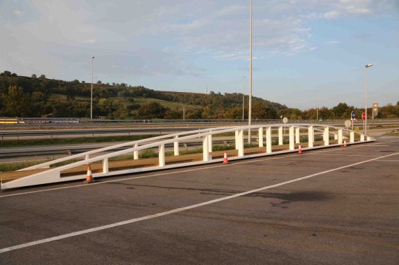 La plataforma que debe colocarse en el puerto de Llanes para comunicar ambas márgenes, está depositada en la gasolinera de la autovía del Cantábrico, en Posada.