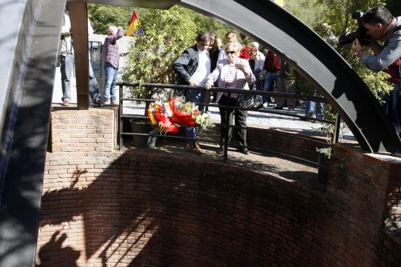 María Teresa Álvarez lanza un ramo de flores al fondo del pozo Fortuna. 