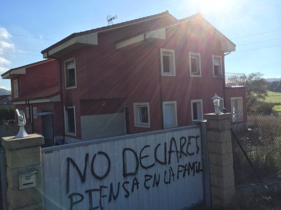 La vivienda en la que se declaró el incendio y el mensaje amenazante en el portón. 