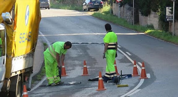 Los operarios, durante la colocación de las bandas en Perán.