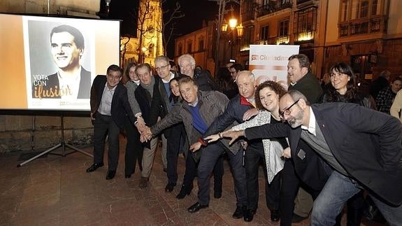 Ciudadanos durante la pegada de carteles.