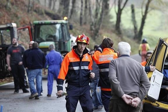 vecinos y efectivos de Protección Civil trabajando ayer cerca de La Barrosa. 