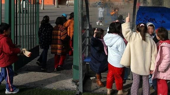 Un grupo de niños a la entrada de un colegio.