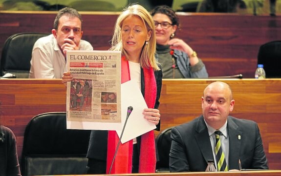 Cristina Coto sostiene en el pleno un ejemplar de EL COMERCIO, cuya portada, relativa a los datos del paro, utilizó para criticar con dureza la gestión económica del Gobierno de Javier Fernández. 