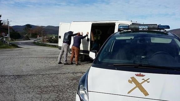 Los dos detenidos apoyados en su furgoneta. 