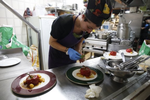 Una cocinera, preparando el plato para la fiesta. 
