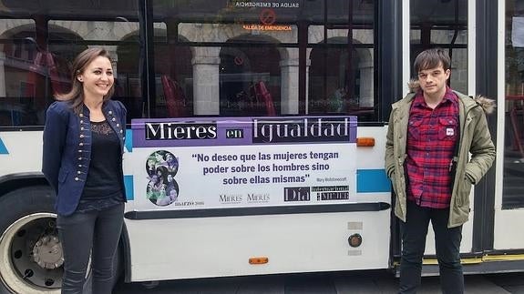 Delia Campomanes y Juan Ponte, junto a un autobús con lemas feministas.