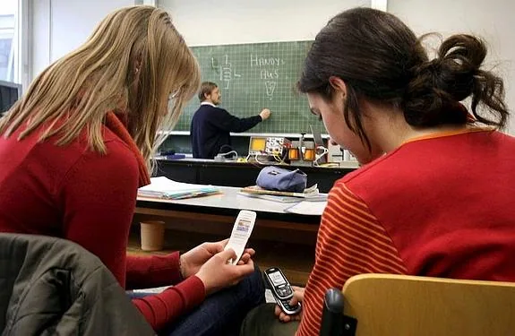 Dos alumnos, con sus móviles, durante una clase. 