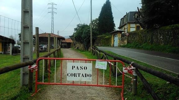 Una valla que alerta de la prohibición de paso en la senda.