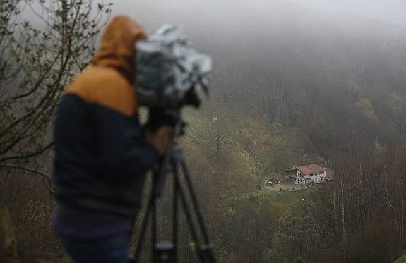 Un cámara de televisión capta imágenes de la casa de La Castañar. en el municipio de Riosa, donde la víctima fue atacada.