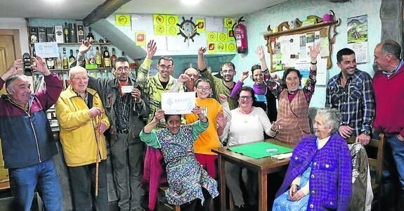 Un grupo de vecinos y agraciados de la localidad sierense de Collao celebran el primer premio vendido, que dejó 3,6 millones en la población. 