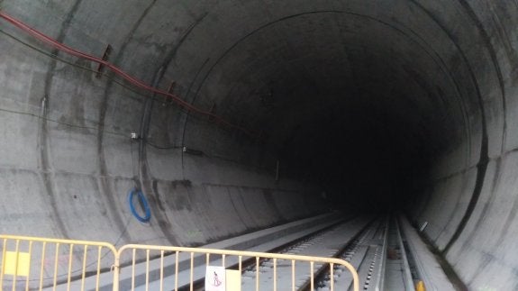 Tras las verjas, el único túnel que se va a equipar tiene la mitad de las vías puestas, pero sigue sin catenaria, ventiladores y las canalizaciones esperando el cable. 