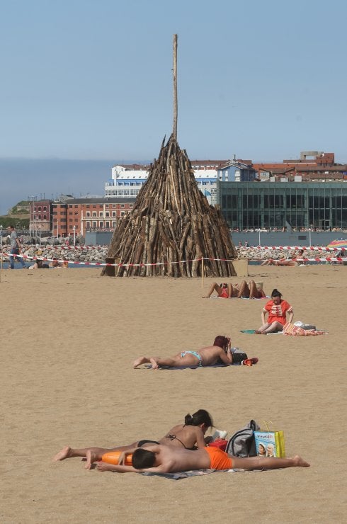 Usuarios de la playa de Poniente, ayer, delante de la hoguera a la que se prenderá fuego esta medianoche. 