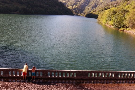 Dos niños, asomados al embalse en Tanes, en Caso. 