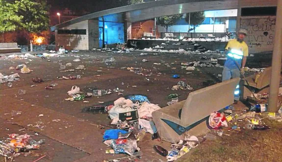 Un operario de la limpieza retira las botellas, bolsas de plástico y demás residuos acumulados junto a la urbanización Nautilus. 