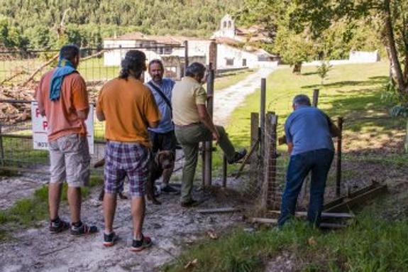 Momento en el que Rogelio Marotías, de Comisiones Obreras, rompe la verja de la finca de San Antolín acompañado por un grupo en el que está de espaldas el edil de Vecinos por Llanes, Alfonso Miyares. 