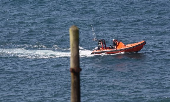 La embarcación enviada por el Ayuntamiento de Gijón navega hacia el Este del concejo para confirmar la desaparición de la concentración de algas y medusas. 