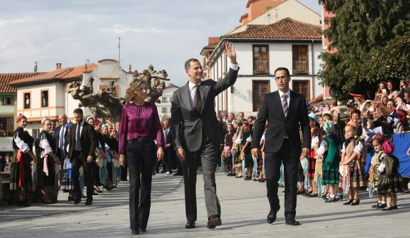 Sus Majestades los Reyes de España pasean por Colombres, ganador del premio el pasado año. 