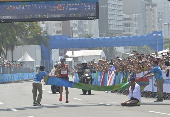 Alberto Suárez, a punto de cruzar la línea de meta en el maratón en Río, mientras el marroquí El Amin Chentouf permanece agotado en el suelo. 