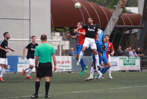 Nacho Fernández, que sustituyó al lesionado Palazuelos, salta en un balón aéreo en su área con Turzo y Espolita. 