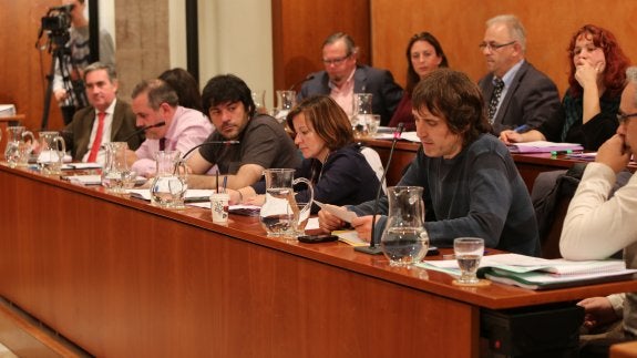 Concejales de Somos, en primer plano, con el grupo del PP al fondo en un Pleno municipal. 