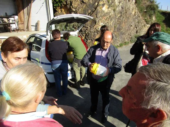 Máximo Braña, responsable de Sanidad Vegetal, entrega trampas para la polilla guatemalteca a los Vecinos de Lourido, en el concejo de San Tirso de Abres. 