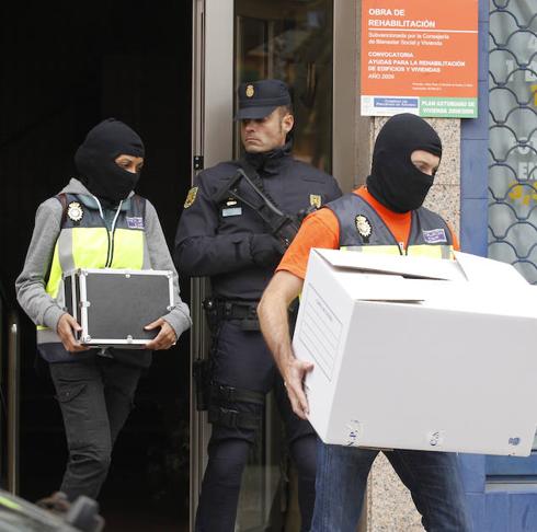 Después de cuatro horas de registro, la Policía abandona el piso con material requisado.