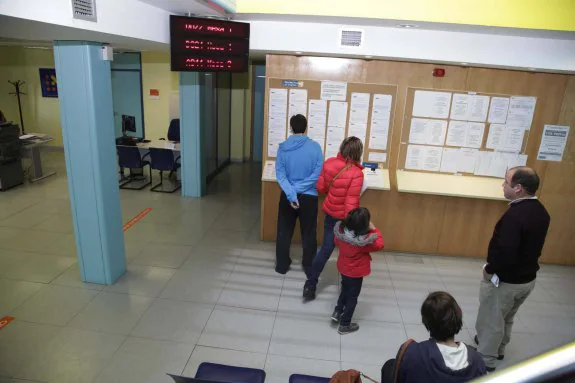 Varias personas consultan las ofertas de trabajo en la oficina que el Servicio Público de Empleo tiene en Llanes. 