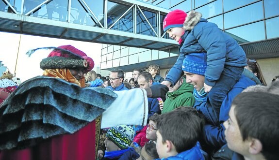 Baltasar saluda a pie de pista a uno de los cientos de niños que se congregaron ayer en el Aeropuerto de Asturias para ver a los Reyes Magos. 