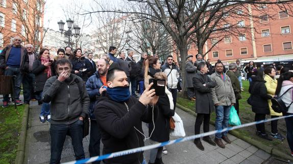 Un grupo de curiosos se agolpa para ver cómo se apaga el fuego del incendio. 