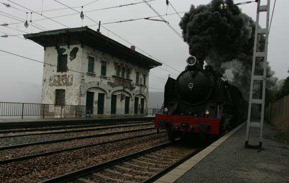 Una vieja máquina de vapor pasa junto a la antigua estación de Pajares, en 2004. 