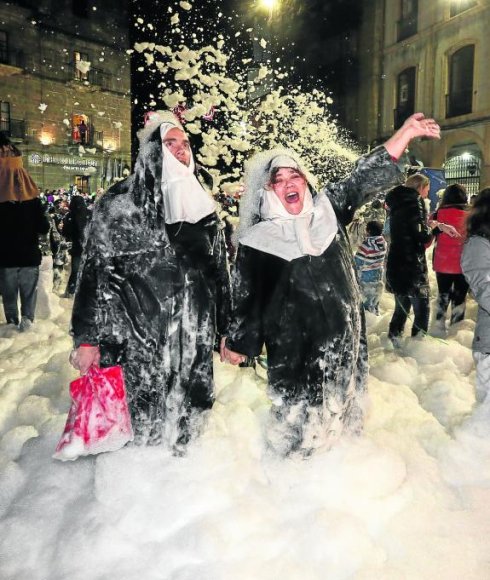 Una pareja de monjas disfruta con la espuma en la plaza de España. 