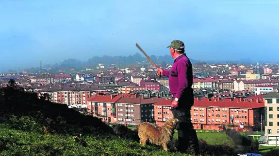 Antoio González, vecino de Lugones, sañala la boina de contaminación que ve desde sus terrenos.