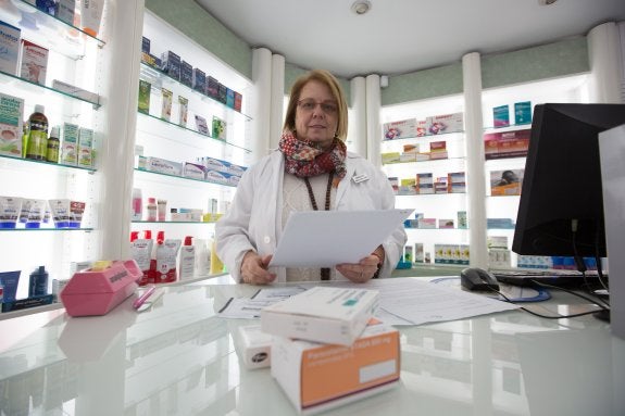 La farmacéutica Inmaculada López consulta las recetas de un paciente. 
