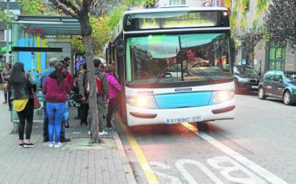 Cola para acceder a uno de los autobuses municipales. 