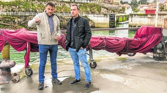 Javier Ardines y Ovidio Zapico ayer, en el puerto de Llanes. Tras ellos, la compuerta. 